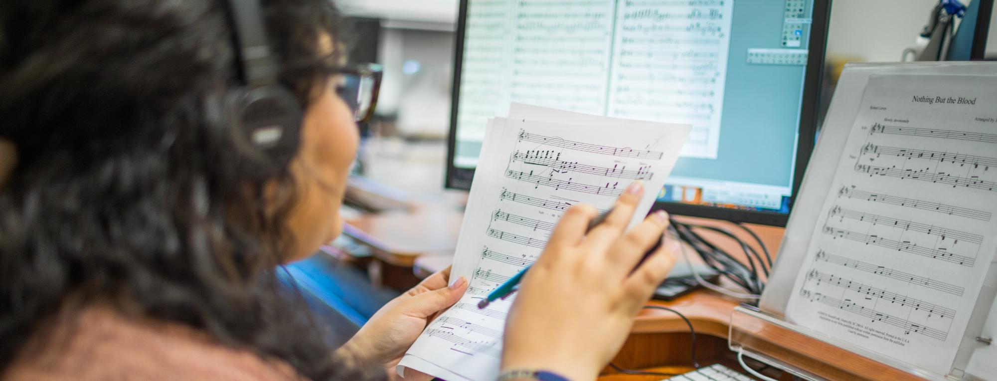 A student works on composing music at her computer